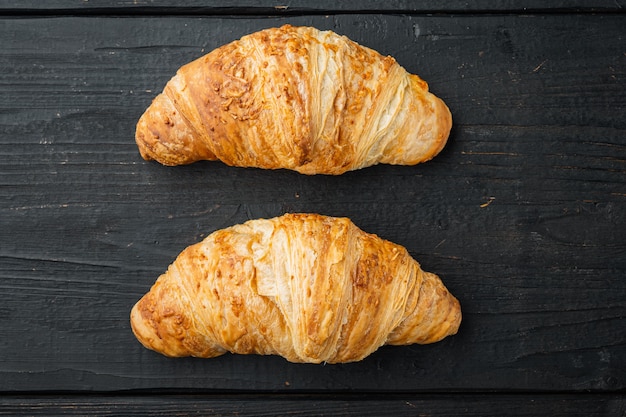 Tasty buttery croissants set, on black wooden table background, top view flat lay