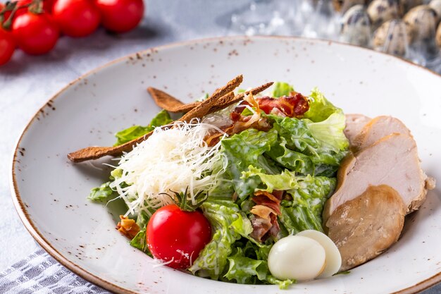 Tasty caesar salad with chicken on a plate.