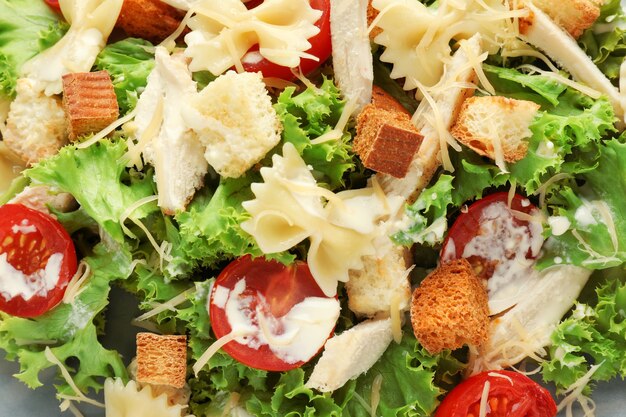 Tasty Caesar salad with pasta, closeup