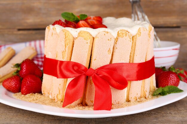 Tasty cake Charlotte with fresh strawberries on wooden table