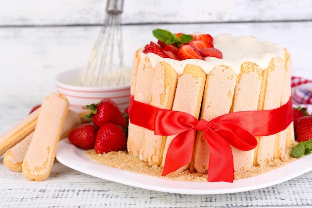 Tasty cake Charlotte with fresh strawberries on wooden table