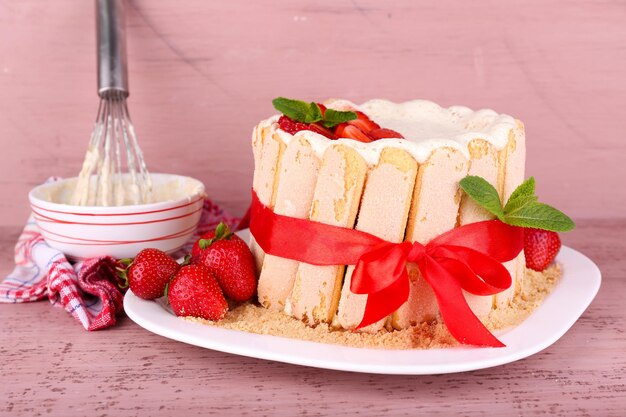 Tasty cake Charlotte with fresh strawberries on wooden table