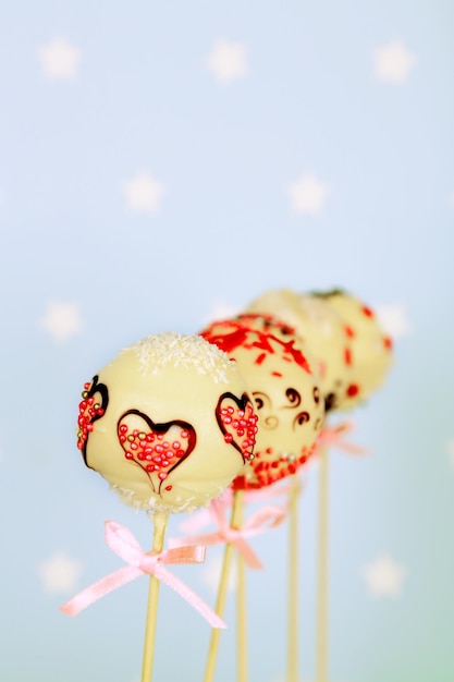 Tasty cake pops on blue background