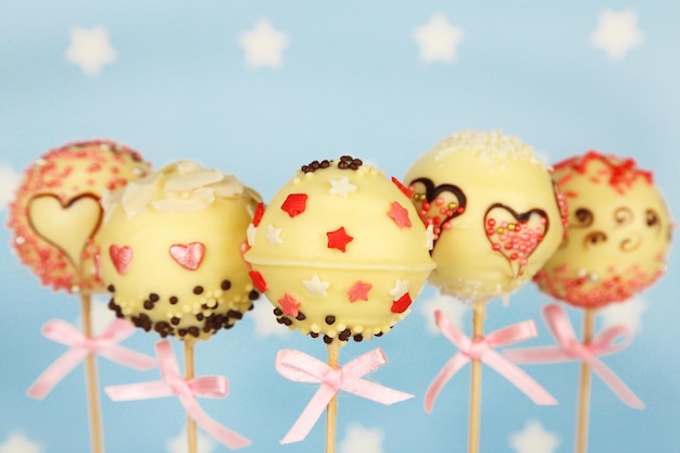 Tasty cake pops on blue background