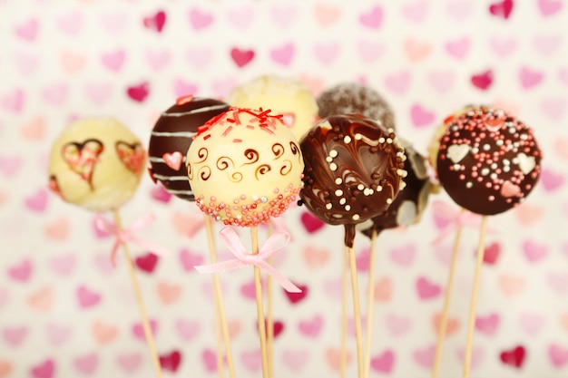 Tasty cake pops on color background