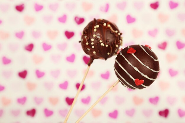 Tasty cake pops on color background