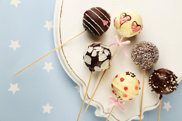 Tasty cake pops on plate, close up