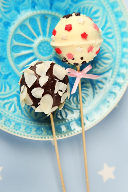 Tasty cake pops on plate, close up