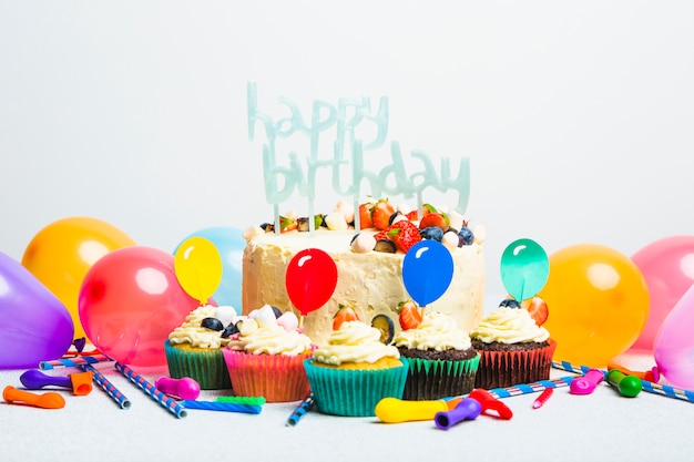 사진 딸기와 생일 축하 제목 머핀과 풍선 세트 근처의 맛있는 케이크