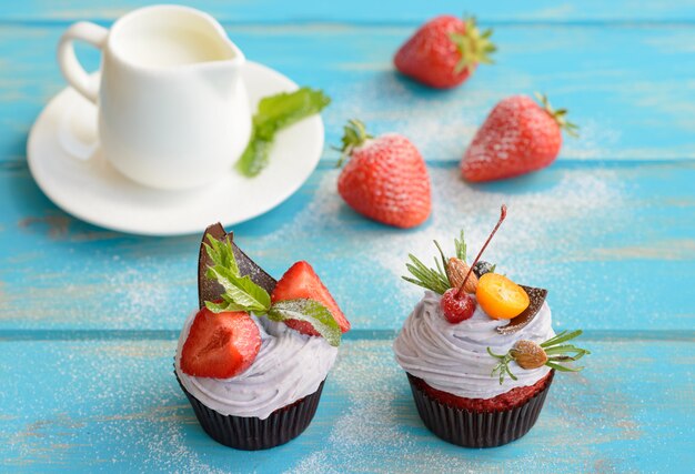 Tasty cake with pieces of fruits and strawberry on a table