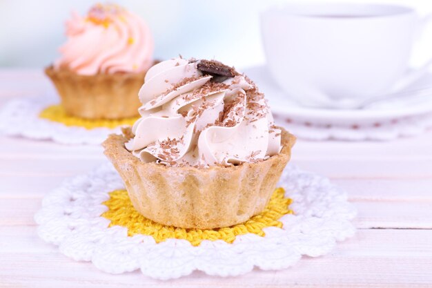 Tasty cakes on table on light background