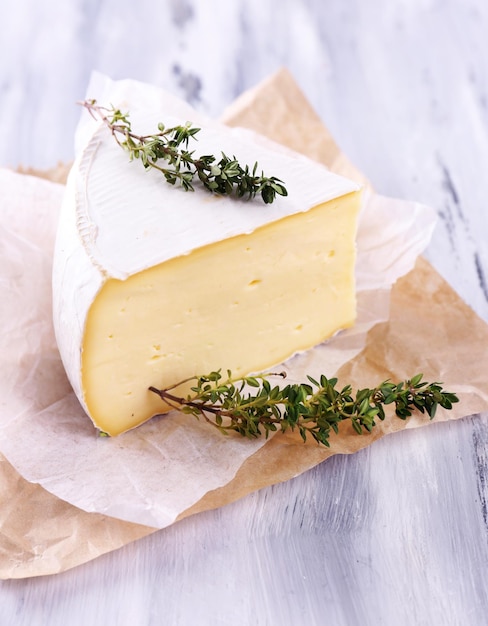 Foto gustoso formaggio camembert con timo su tavola di legno