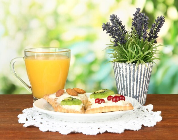 Tasty canapes with cheese kiwi and cranberry almond on color plate on bright background