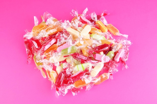 Tasty candies on pink background