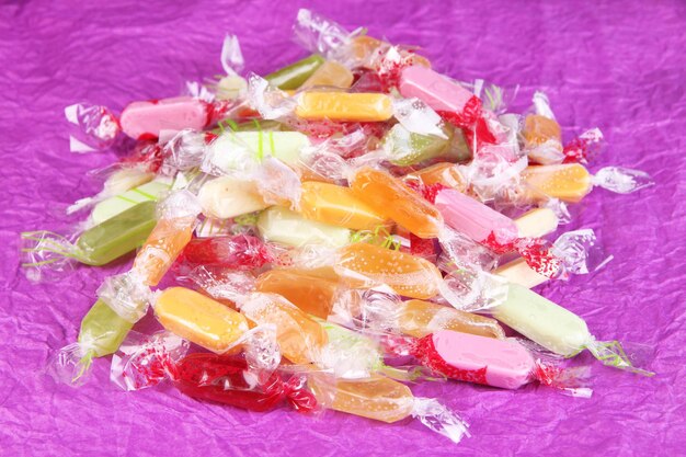 Tasty candies on purple background