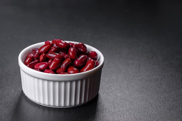 Tasty canned red beans in a beautiful white bowl on a wooden board