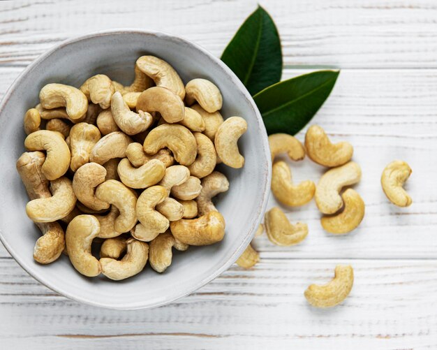 Tasty cashew nuts in bowl on a old wooden table