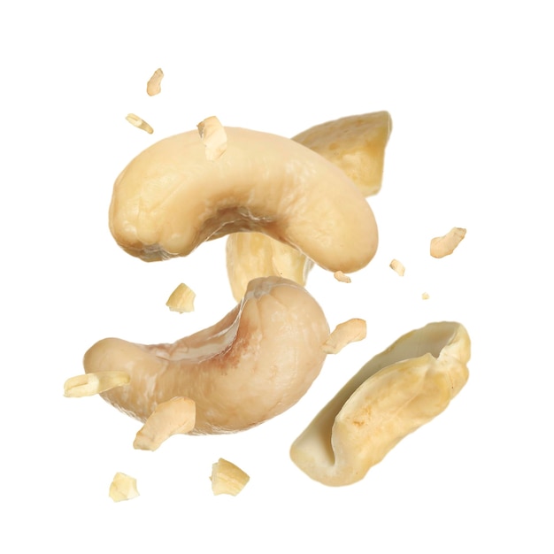 Tasty cashew nuts flying on white background