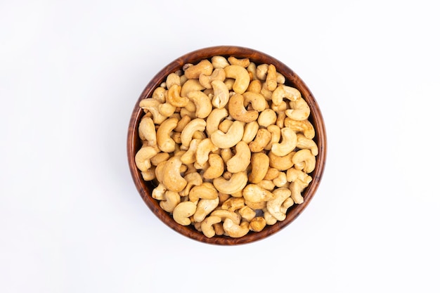 Tasty Cashew nuts in wooden bowl white background