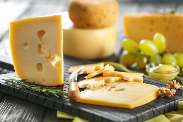 Tasty cheese on wooden board closeup