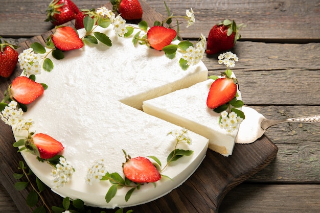 Tasty cheesecake with strawberries on a wooden background. Beautiful composition