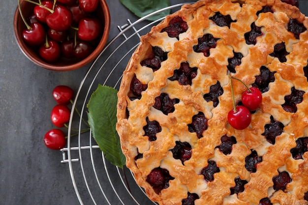 Tasty cherry pie and fresh berries on table