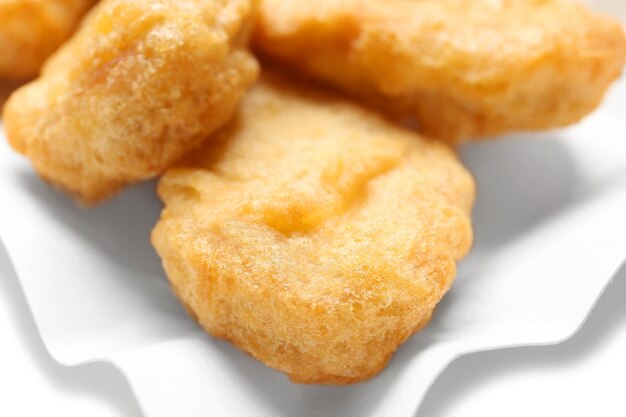 Foto deliziose nuggets di pollo su un piatto di carta da vicino