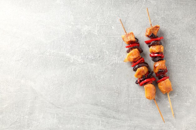 Tasty chicken shashlik on gray textured background