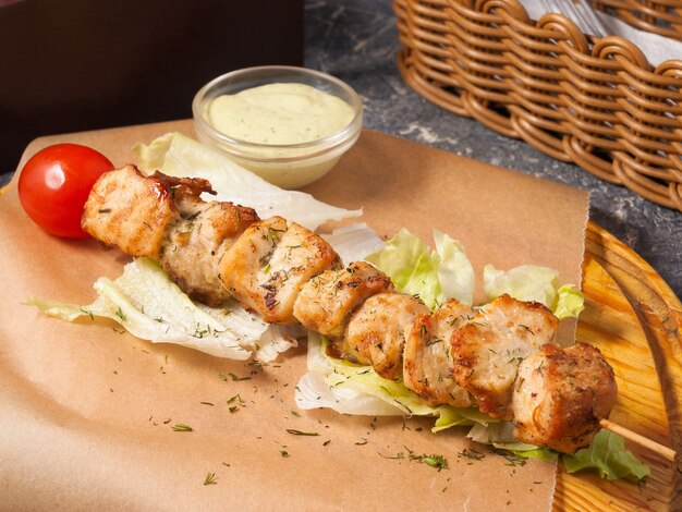 Photo tasty chicken skewer with sauce on a wooden board