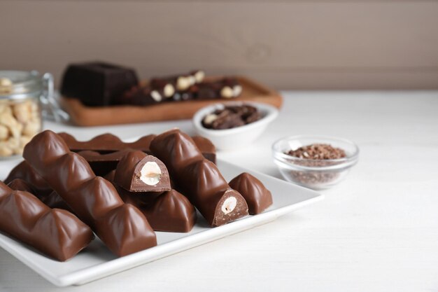 Tasty Chocolate Bars with Nuts on White Wooden Table