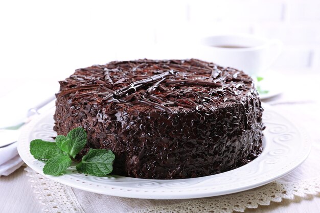 Tasty chocolate cake with cup of tea on table close up