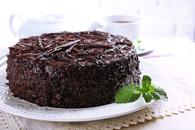 Tasty chocolate cake with cup of tea on table close up