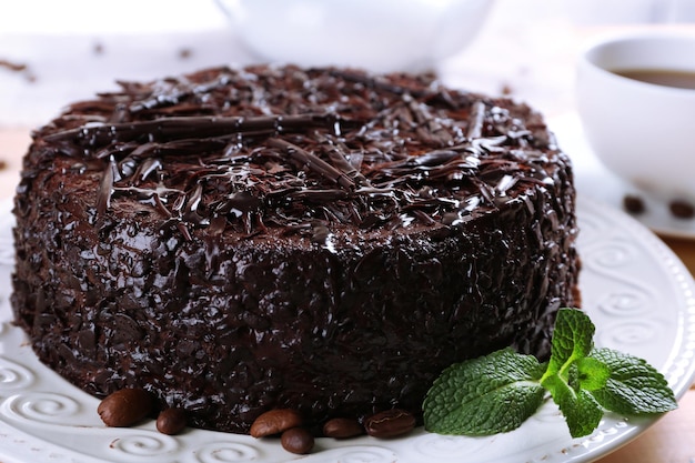 Tasty chocolate cake with cup of tea on table close up