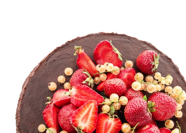 Tasty chocolate cake with strawberries and currants on white