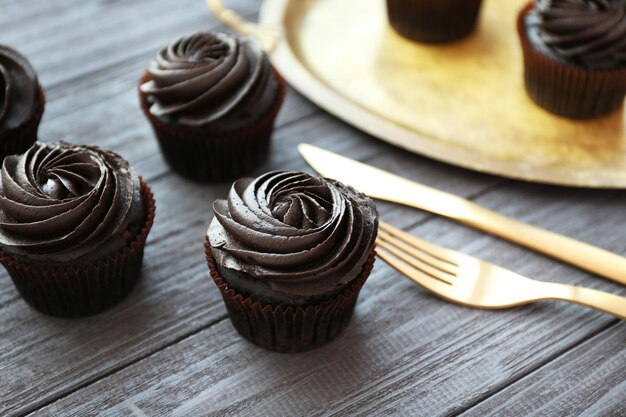 Tasty chocolate cupcake on wooden table