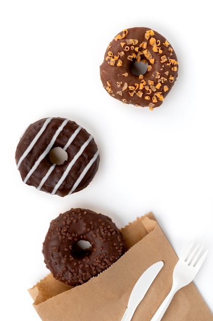 Tasty chocolate donuts on white surface