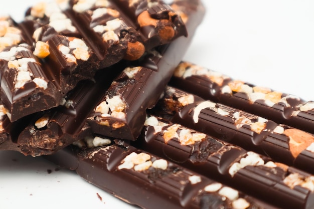 Tasty chocolate with nuts Chocolate pieces with nuts on white background Selective focus