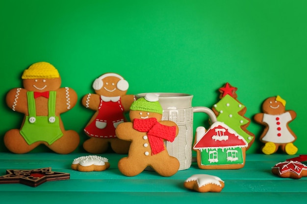 Tasty Christmas homemade cookies and cup on color background