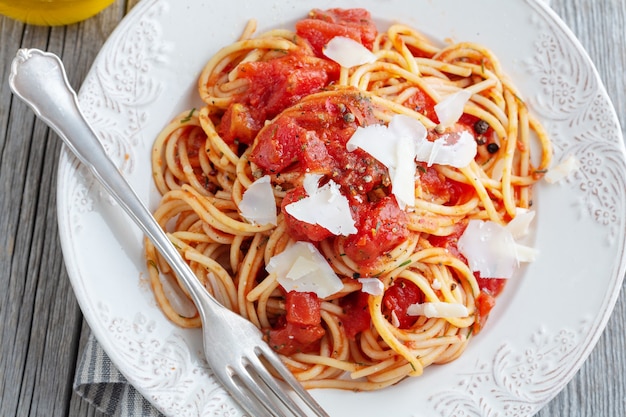 Gustosa pasta italiana classica con salsa di pomodoro e formaggio sul piatto. avvicinamento.