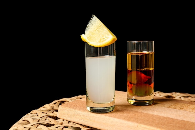 Photo tasty cocktails on wicker table and black background