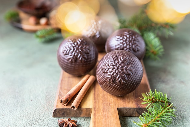 Tasty cocoa bombs with marshmallow and chocolate with fir branches and spices Trendy winter drink