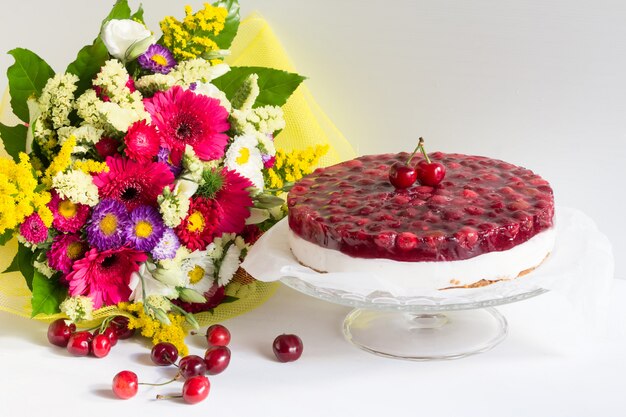 Foto gustosa cheesecake fredda con gelatina di ciliegie e fiori