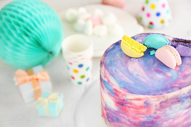 Photo tasty color cake with macaroons on table