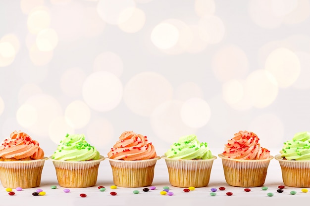 Photo tasty colorful cupcakes closeup on bokeh background with copy space. birthday party sweets