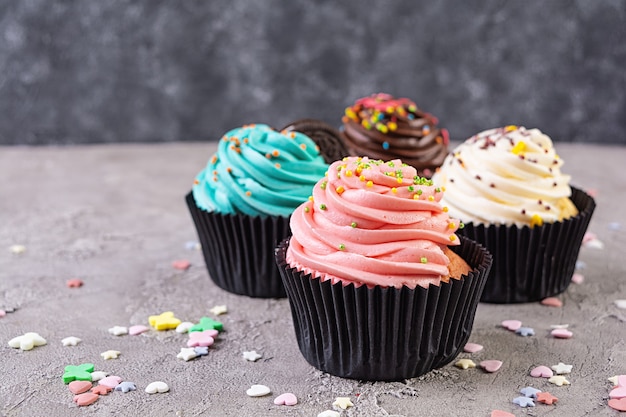 Tasty colorful cupcakes isolated on grey