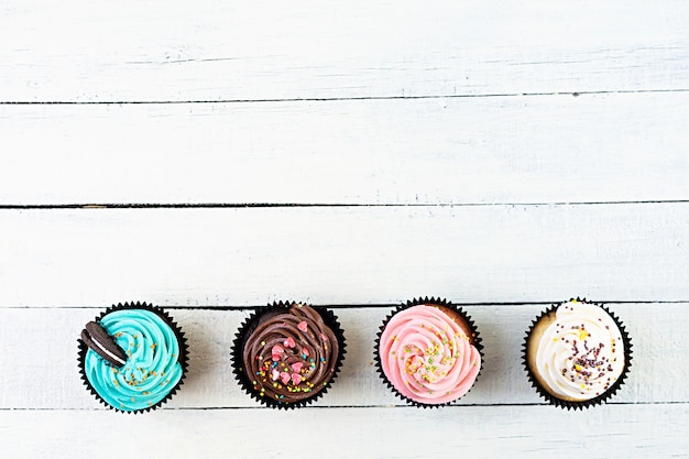 Tasty colorful cupcakes isolated on white