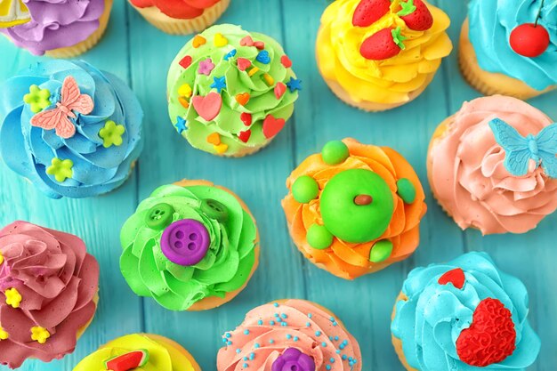 Tasty colorful cupcakes on wooden background