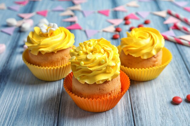 Tasty colorful cupcakes on wooden table