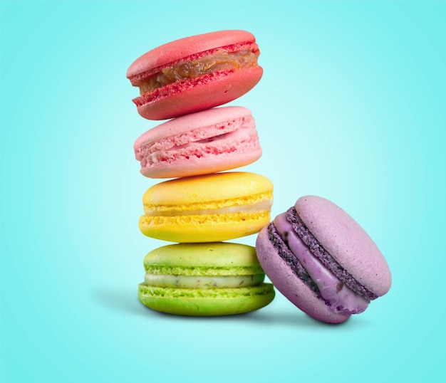 Tasty colourful macaroons cookies on blue background