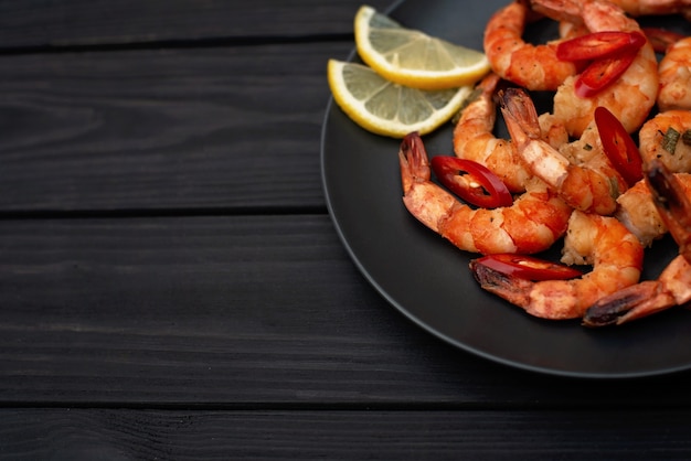Tasty cooked fried shrimp with chilli and lemon. Copy space. Flat lay.